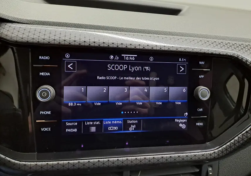 Écran tactile central du Volkswagen T-Cross 2022 R-Line, affichant la radio SCOOP Lyon avec cadre décoratif gris à motifs géométriques.