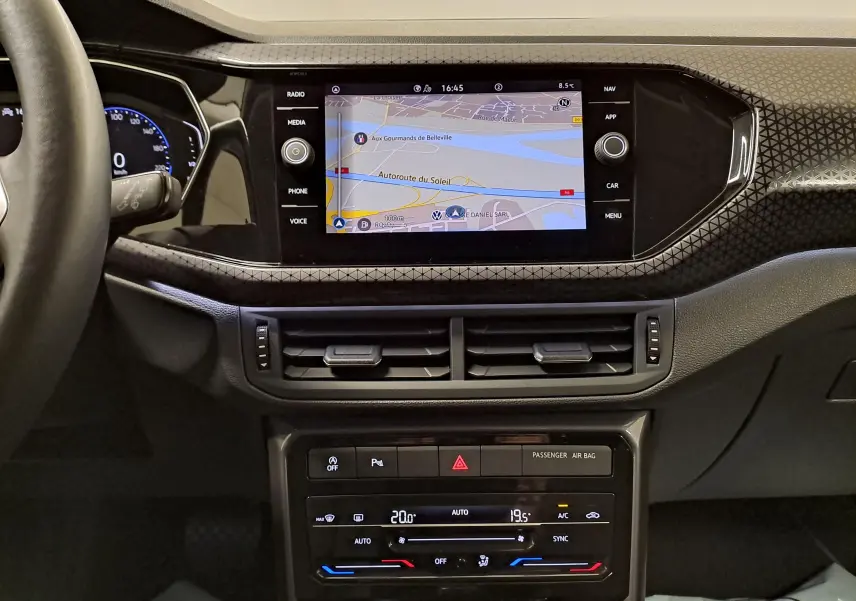 Vue intérieure du tableau de bord du Volkswagen T-Cross 2022 R-Line, avec écran tactile et finition noire à motifs géométriques.