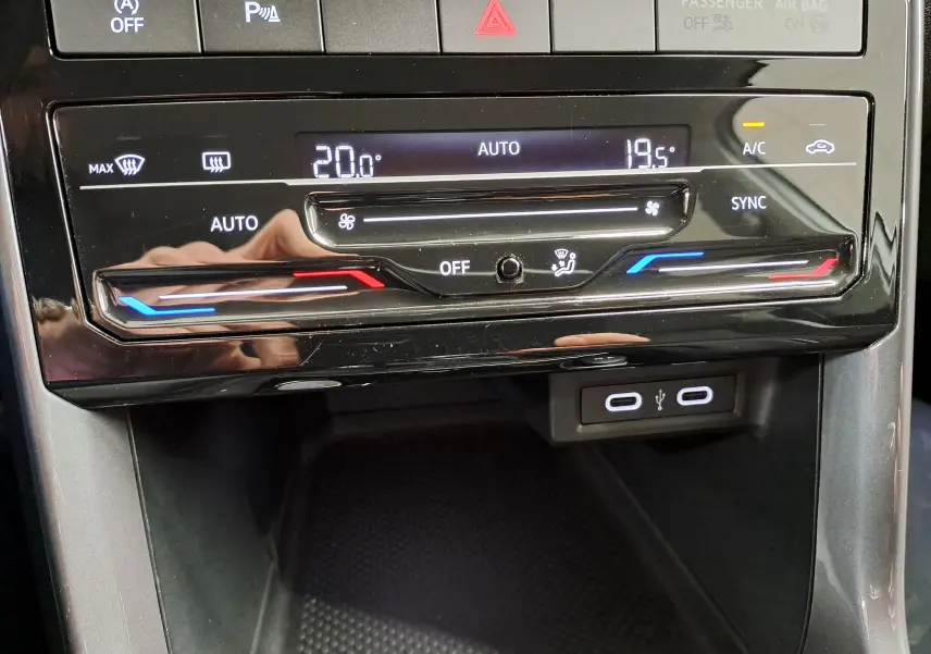 Vue rapprochée de la commande de climatisation digitale du Volkswagen T-Cross R-Line 2022 avec affichage des températures et ports USB.