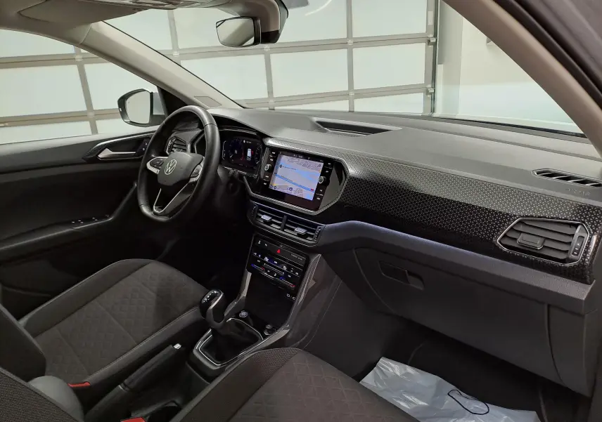 Vue intérieure côté conducteur du Volkswagen T-Cross 2022, tableau de bord noir avec écran tactile et volant multifonction.