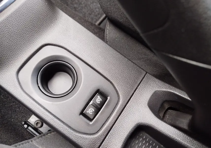 Gros plan sur la console centrale noire du Dacia Duster 2020, montrant deux boutons de réglage des rétroviseurs.