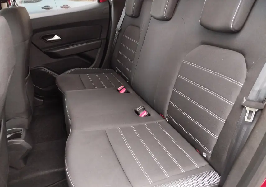 Vue intérieure côté droit des sièges arrière en tissu gris avec surpiqûres blanches du Dacia Duster Rouge Fusion 2020.