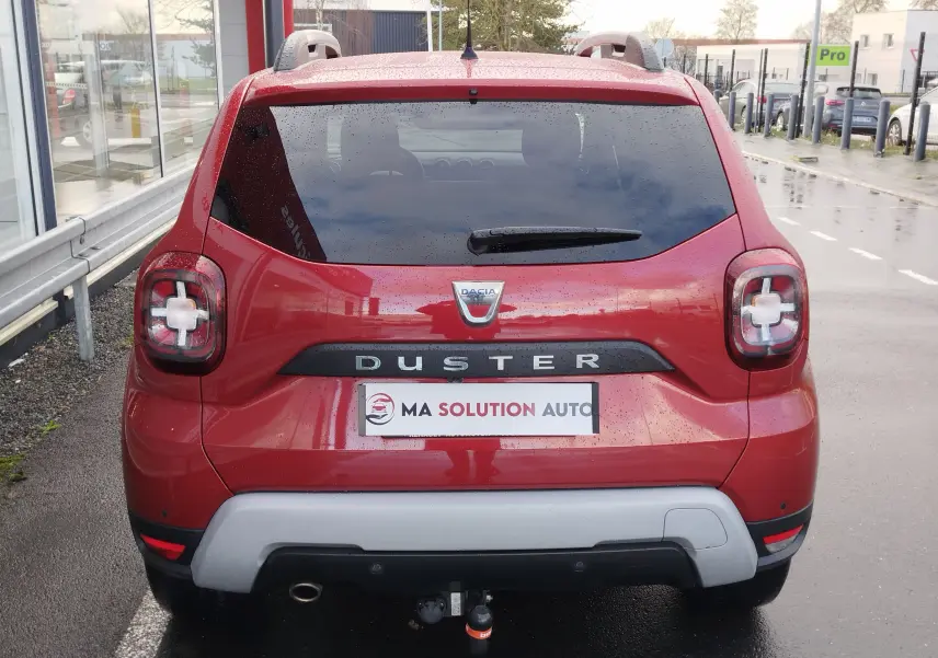 Vue arrière d'un Dacia Duster rouge Fusion 2020 avec feux arrière caractéristiques et attelage visible.