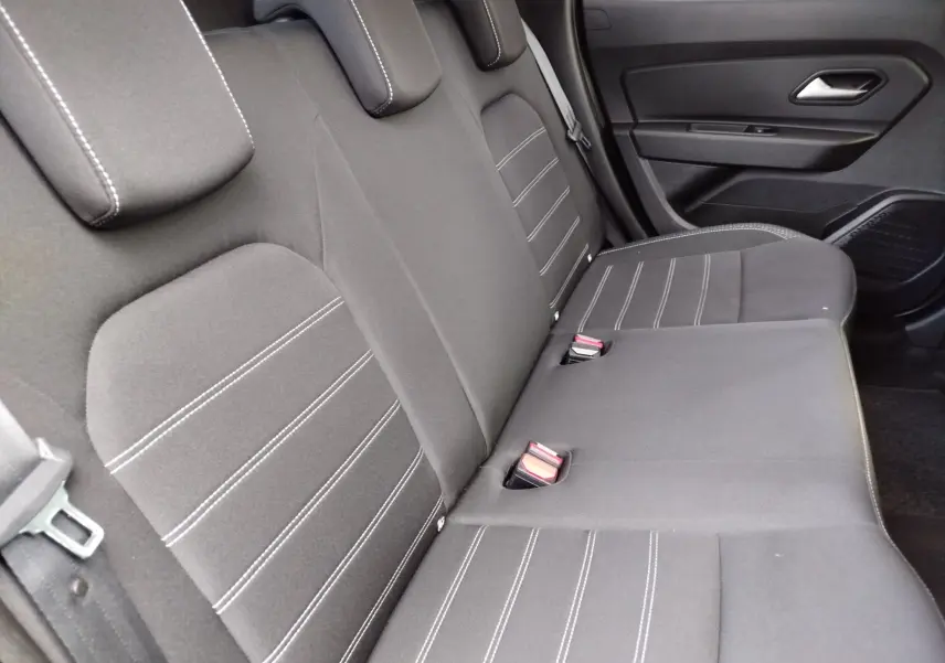 Vue intérieure de la banquette arrière en tissu gris avec surpiqûres blanches du Dacia Duster 2020.