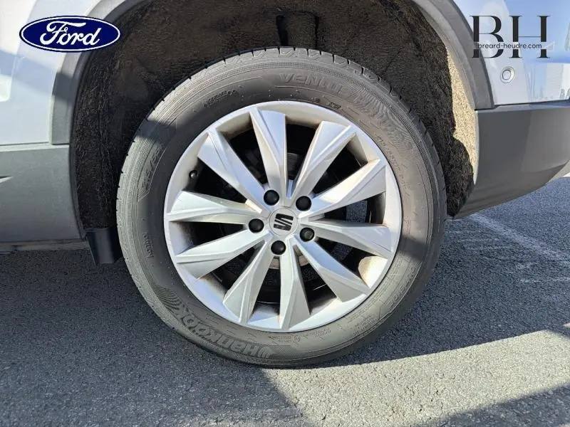 Gros plan sur la roue avant droite d’un SEAT Ateca argent Reflex Métal avec jante alliage et logo central SEAT.