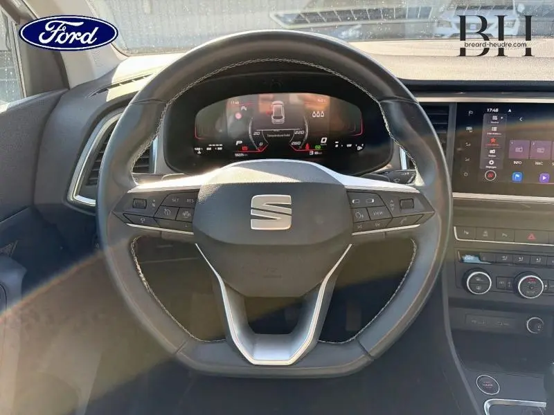 Vue centrée sur le volant cuir multifonction du SEAT Ateca 2023 avec tableau de bord numérique et écran tactile côté droit.