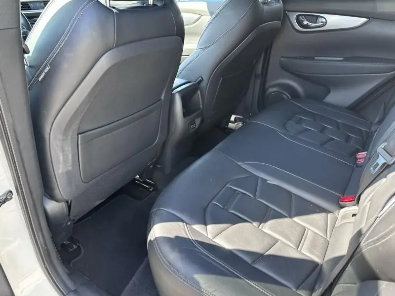 Vue intérieure arrière côté droit du Nissan Qashqai 2019 blanc, sièges en cuir noir avec surpiqûres distinctives.