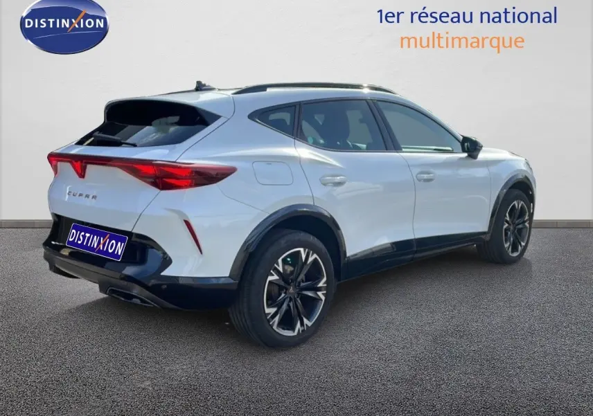 Vue 3/4 arrière droite d'un CUPRA Formentor blanc neige métal avec jantes noires et toit noir contrasté.