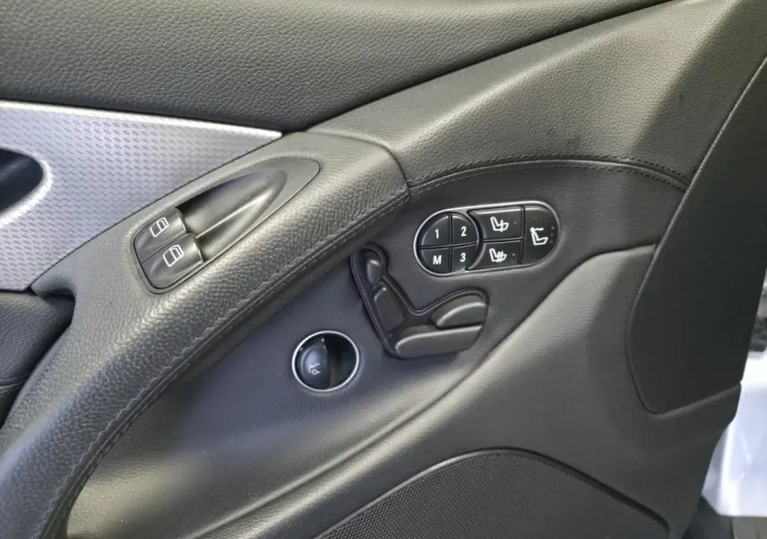 Détail de la porte intérieure côté conducteur de la Mercedes SL 350 gris, avec commandes de sièges et boutons de vitres.