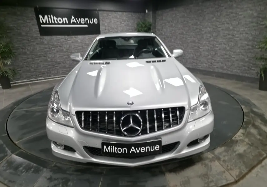Vue avant d'une Mercedes SL 350 gris métallisé avec calandre verticale et logo étoile bien visible.