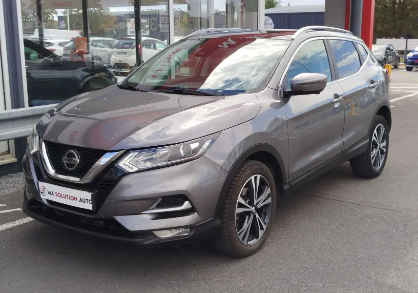 Nissan Qashqai gris Squale en 3/4 avant droit, avec jantes alliage et calandre chromée visible en concession.