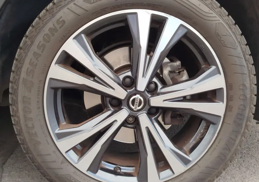 Gros plan sur la jante alliage bicolore du Nissan Qashqai Gris Squale, mettant en valeur le logo central et le pneu Goodyear.