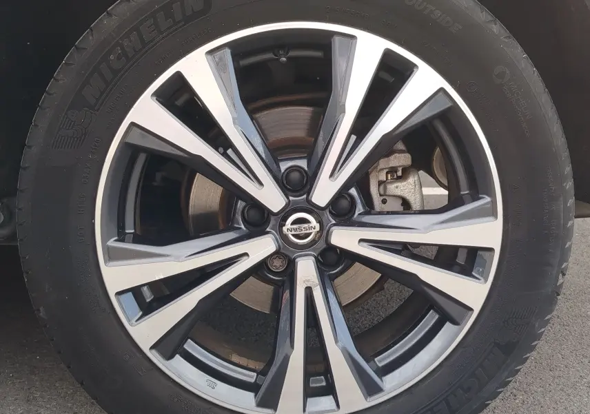 Gros plan sur la jante alliage bicolore du Nissan Qashqai 1.5 dCi 2019 en gris Squale avec logo central Nissan visible.