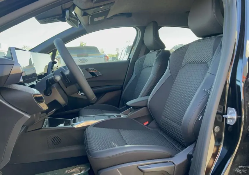 Intérieur avant droit de la Renault Clio 6 TCE 115 EDC Techno 2026 noir étoilé, sièges tissu noir avec surpiqûres.