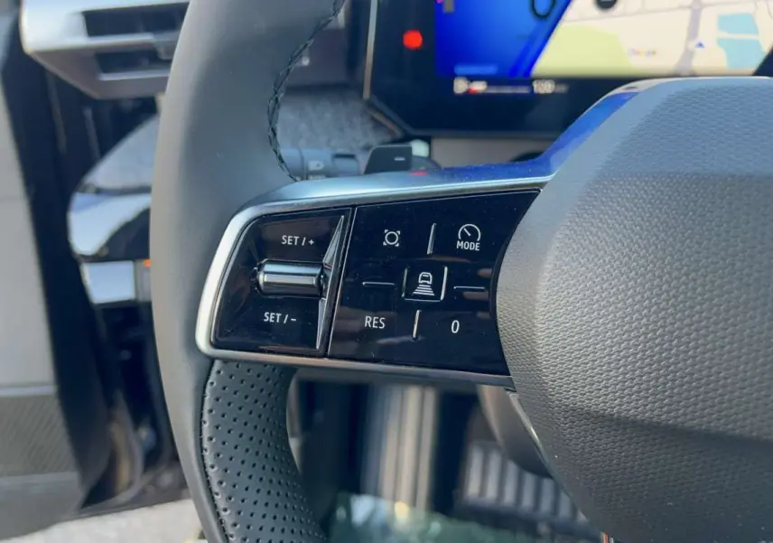 Gros plan sur les commandes multifonctions côté gauche du volant textile noir de la Renault Clio 6 TCE 115 EDC TECHNO.