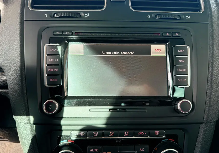 Écran central tactile de la Volkswagen Golf 1.4 TSI 2012 avec commandes radio et climatisation visibles en gros plan.