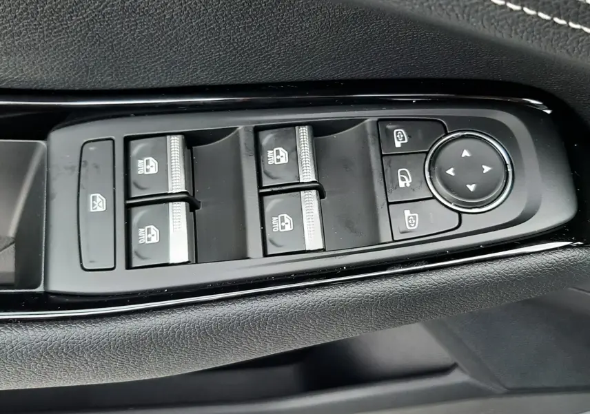 Gros plan sur les commandes de lève-vitres et rétroviseurs côté conducteur du Renault Austral gris schiste 2025.