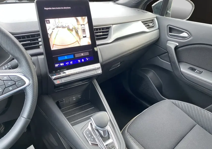 Vue intérieure côté passager du Renault Symbioz 2025, avec écran tactile central affichant la caméra de recul et console noire moderne.