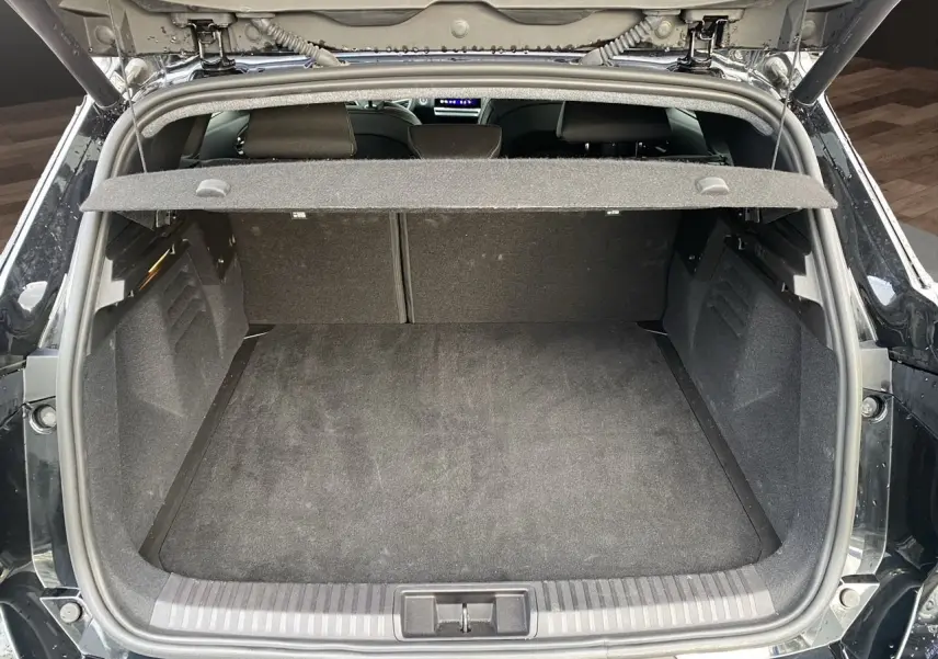 Coffre ouvert vu de l'arrière d'une Renault Symbioz noire étoile, montrant un espace de chargement propre et spacieux.