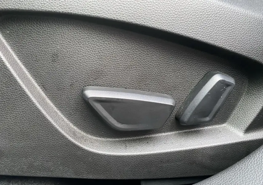 Gros plan sur les commandes de réglage électrique du siège côté conducteur du Renault Symbioz noir étoile 2025.