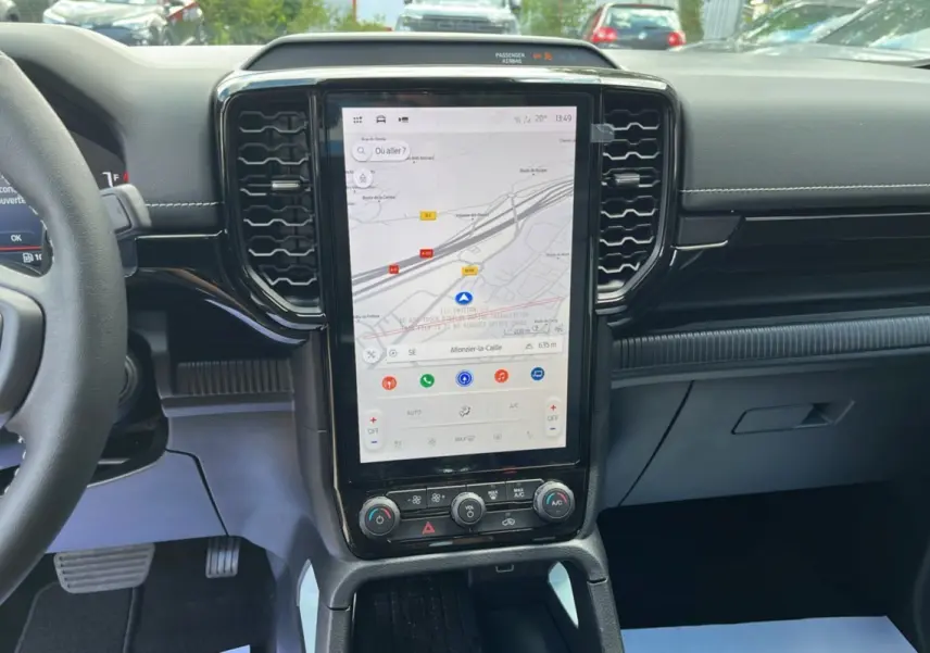 Vue intérieure centrée sur la console centrale tactile verticale du Ford Ranger gris zen avec volant partiel à gauche.