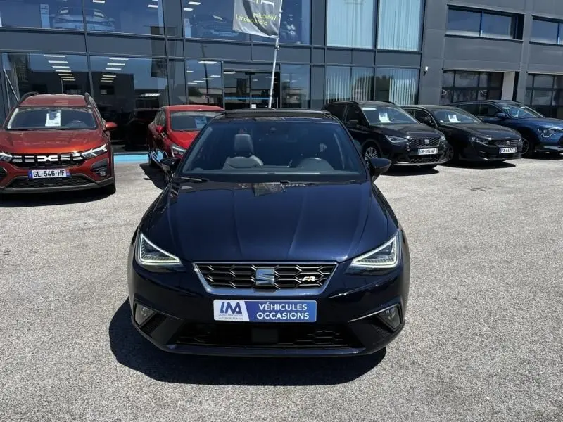 Vue avant d'une SEAT Ibiza 1.5 TSI FR Xclusive bleu foncé métal, avec calandre distinctive et feux LED allumés.