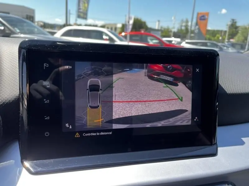 Écran tactile intérieur montrant la caméra de recul avec vue arrière et lignes de guidage vertes et rouges.