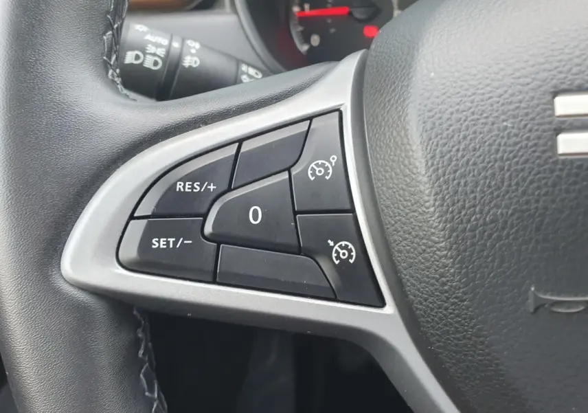 Gros plan sur les commandes du régulateur de vitesse au volant du Dacia Duster 2023, finition Extreme.