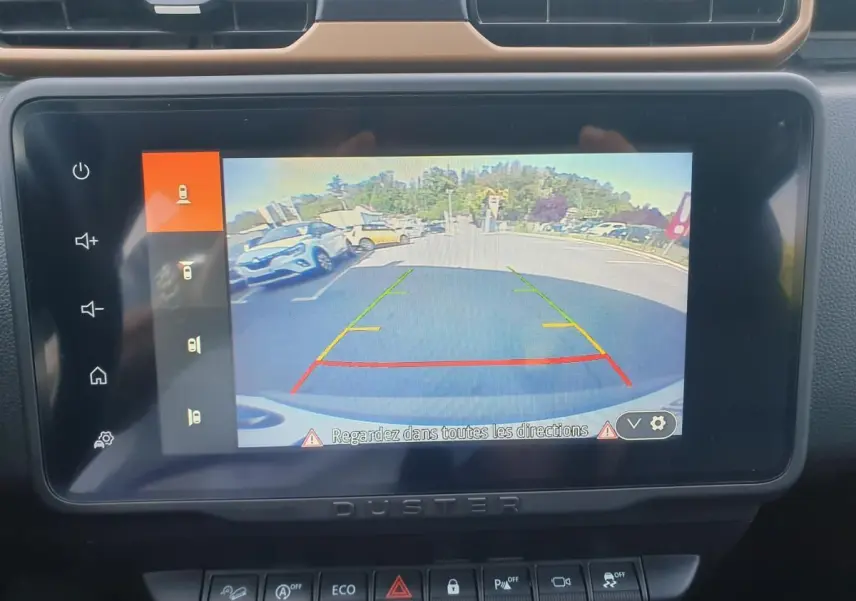 Écran central du Dacia Duster 2023 montrant la caméra 360 en marche, avec vue arrière du parking.