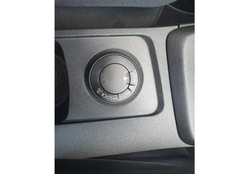 Gros plan sur le sélecteur de mode 4x4 du Dacia Duster gris urbain, situé sur la console centrale.