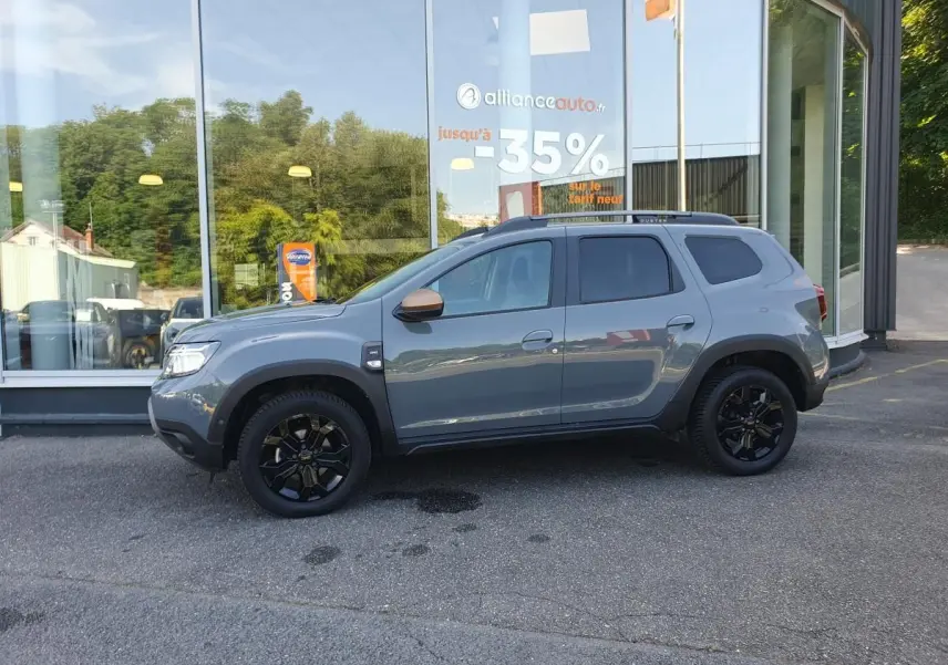 Profil droit du Dacia Duster 1.5 DCI 115 Extreme 4x4 gris urbain avec jantes noires et vitres surteintées.
