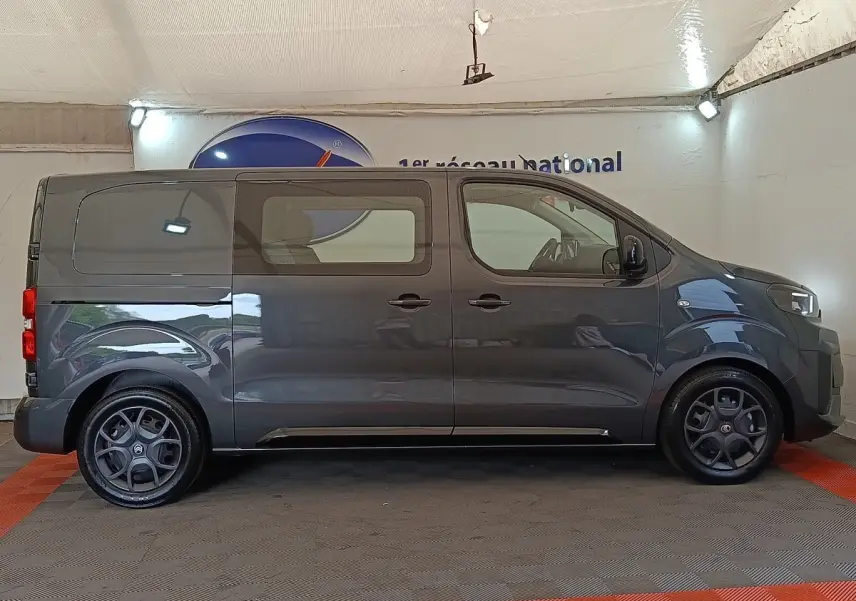 Vue de profil côté gauche d'un Citroën Jumpy gris foncé 2025 avec vitres latérales et jantes noires.