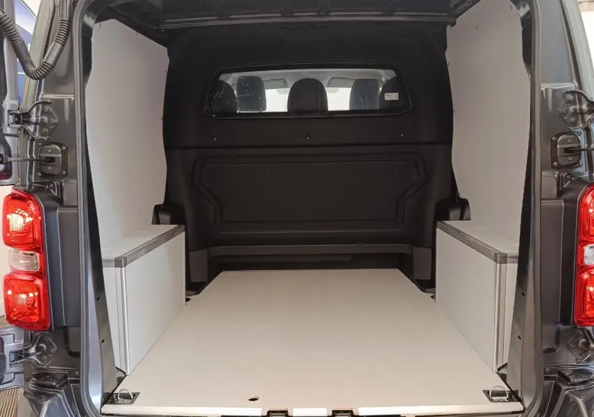 Vue arrière du Citroën Jumpy gris foncé 2025 montrant l’espace de chargement vide avec cloison vitrée pleine.