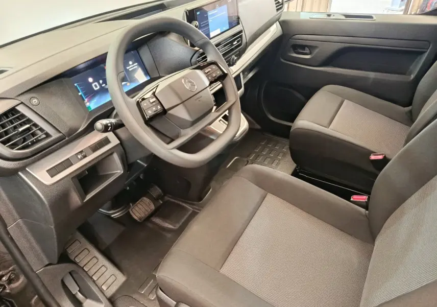 Vue intérieure côté conducteur du Citroën Jumpy 2025 gris foncé, avec volant multifonctions et tableau de bord digital.