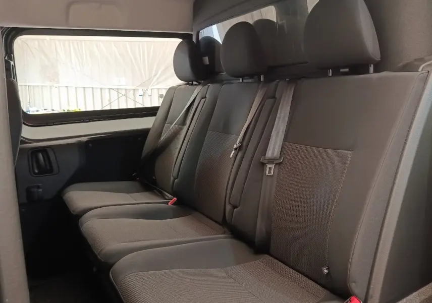 Banquette arrière grise du Citroën Jumpy 2025 vue de côté gauche avec ceintures et appuie-têtes visibles.