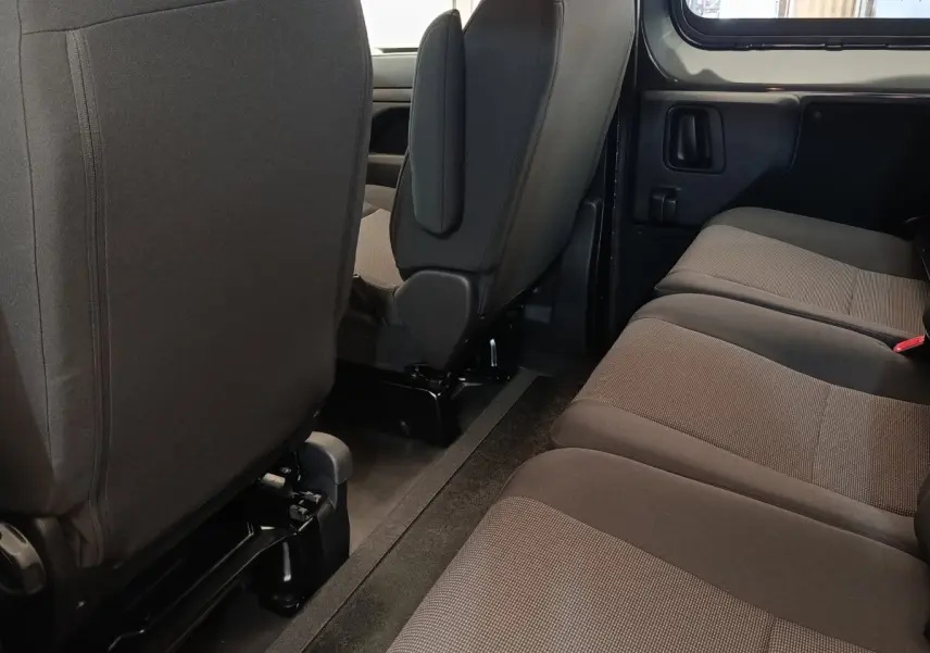 Vue intérieure du côté droit de la banquette arrière grise du Citroën Jumpy M Diesel 2025 avec sièges avant en tissu noir.