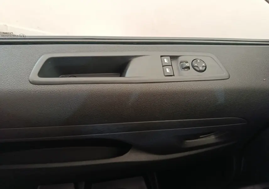 Détail de la commande des vitres et rétroviseurs sur la portière côté conducteur d’un Citroën Jumpy gris foncé 2025.