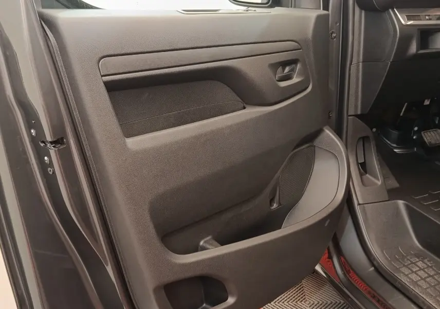 Vue rapprochée de la porte côté conducteur gris foncé du Citroën Jumpy 2025 avec rangement et haut-parleur intégré.