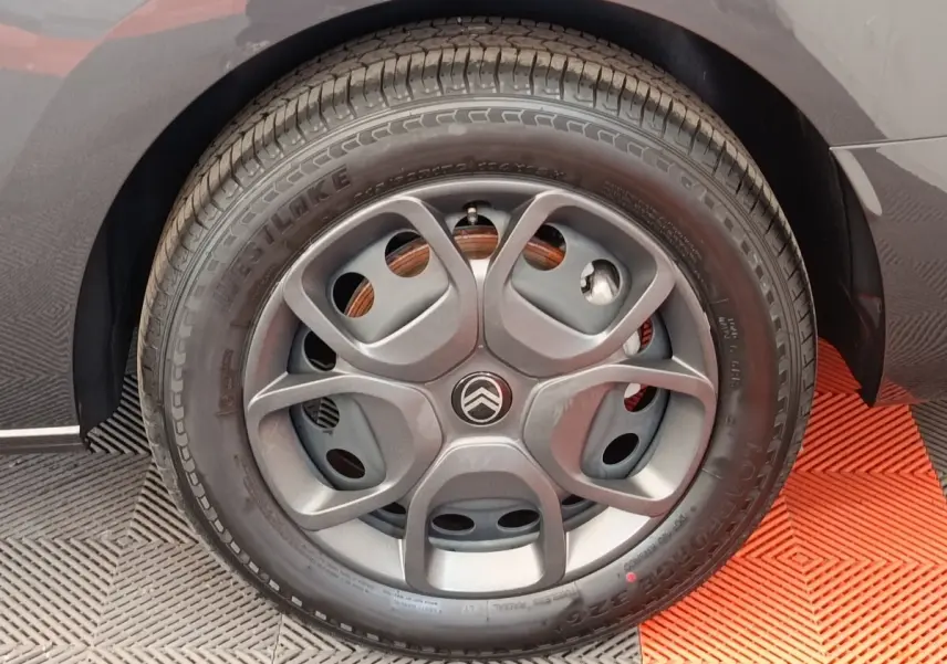 Gros plan sur la roue arrière droite d’un Citroën Jumpy gris foncé, avec partie de la carrosserie visible.