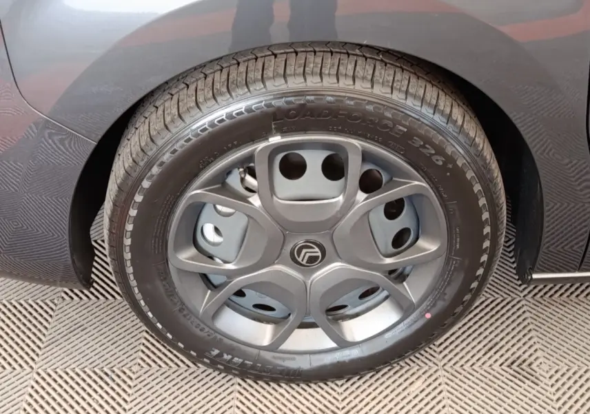 Gros plan sur la roue arrière droite du Citroën Jumpy gris foncé, montrant le pneu et l'aile du véhicule.
