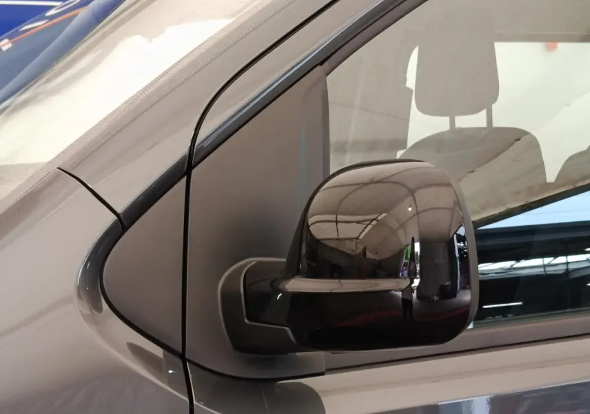 Gros plan sur le rétroviseur droit noir du Citroën Jumpy gris foncé, avec reflet de l'environnement intérieur.