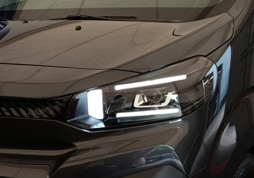 Gros plan sur le phare avant droit allumé du Citroën Jumpy gris foncé 2025, mettant en valeur sa signature lumineuse LED.