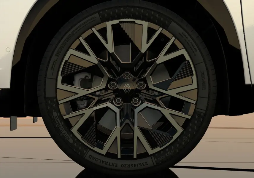 Gros plan sur la roue avant droite du Renault Austral blanc nacré, jante noire au design géométrique distinctif.