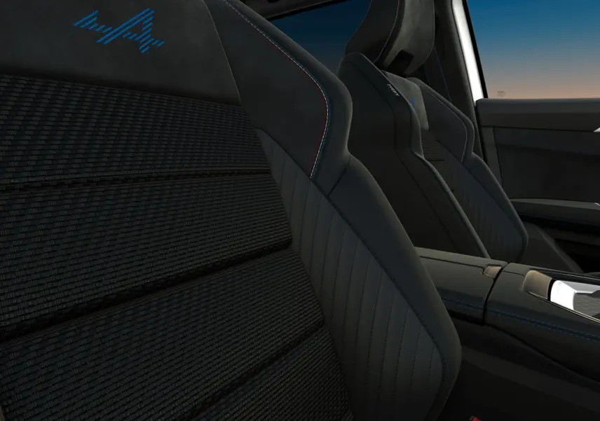 Gros plan sur les sièges avant noirs du Renault Austral Esprit Alpine, avec surpiqûres bleues et logo "A" brodé.