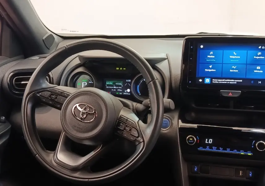 Vue intérieure frontale du tableau de bord de la Toyota Yaris Cross 2022 avec volant cuir et écran tactile central.