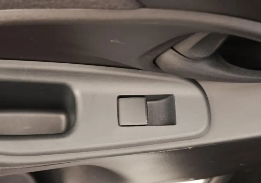 Détail du bouton de commande de la vitre côté gauche intérieur de la Toyota Yaris Cross blanche 2022 hybride.