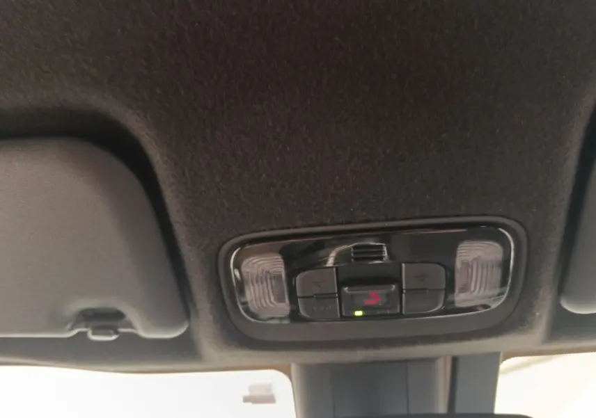 Plafonnier intérieur avec commandes d’éclairage et appel d’urgence dans une Toyota Yaris Cross blanche, vue de dessous.