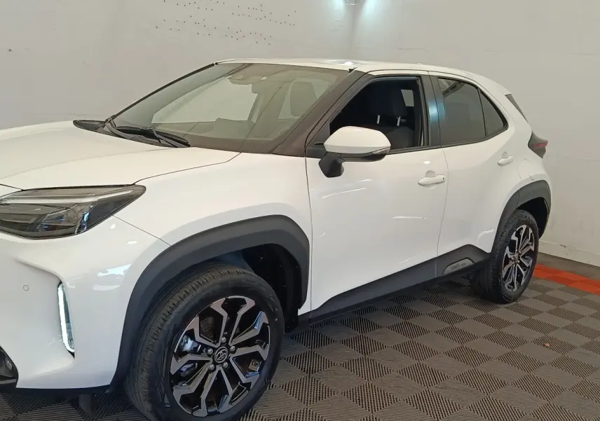Toyota Yaris Cross blanc vue 3/4 avant droit, avec jantes noires et éléments de carrosserie noirs contrastants.