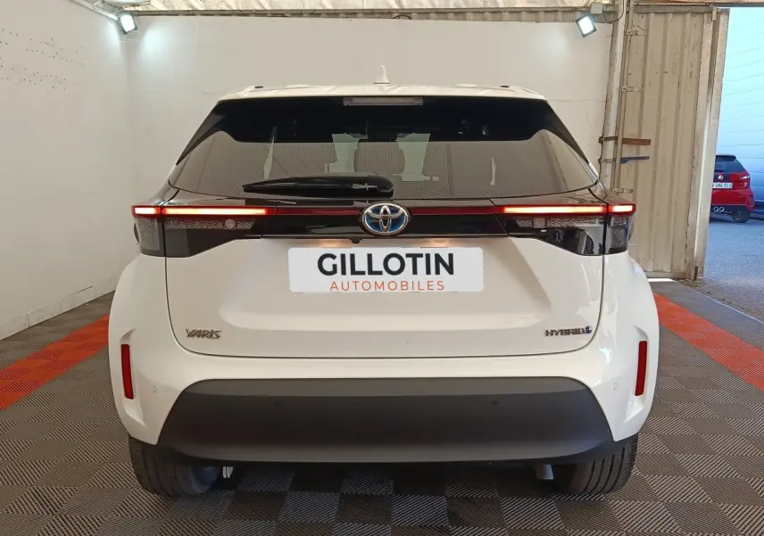 Vue arrière d'une Toyota Yaris Cross blanche hybride 2022 avec feux LED fins et logo Toyota central.