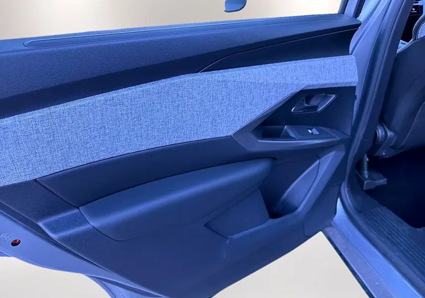 Vue rapprochée de la porte arrière gauche du Peugeot 5008 Hybrid 145 allure e-dcs6 gris artense, avec tissu gris clair et plastique noir.
